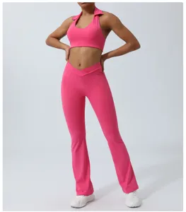Pink yoga outfit detail view showing halter crop top and flared trousers in stretch fabric.