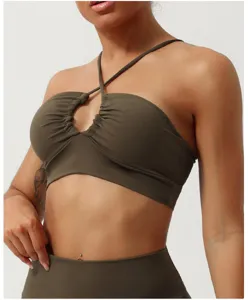 Reggiseno sportivo incrociato traforato in dettaglio, top yoga fitness verde oliva primo piano.