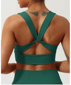 Vue détaillée du soutien-gorge de sport vert foncé à dos croisé, bretelles et tissu respirant.