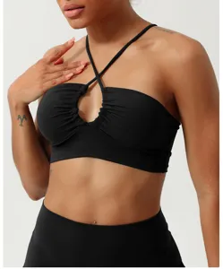 Vista dettagliata del reggiseno sportivo push-up nero con spalline incrociate per yoga.