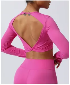 Vista detallada del crop top rosa de manga larga con elegante espalda descubierta y nudo cruzado.