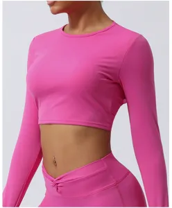 Top corto deportivo de manga larga rosa para mujer, prenda de yoga y fitness ajustada.