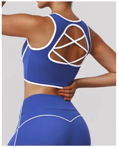Reggiseno sportivo blu con rifiniture bianche e schiena incrociata, elegante crop top da fitness.