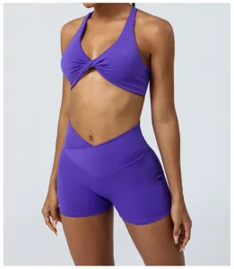 Set yoga viola da donna, reggiseno sportivo con nodo e pantaloncini fitness a vita alta.