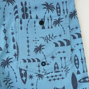 Dettaglio pantaloncini da bagno uomo, costume surf blu tropicale con tasca posteriore.