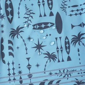 Vista dettagliata del tessuto per pantaloncini da surf con stampa retrò e gocce d'acqua.