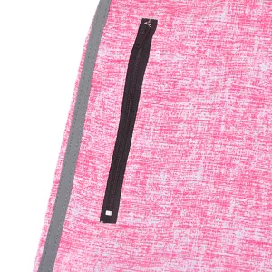 Close-up detail of pink stretch beach shorts pocket with zipper and reflective stripe.