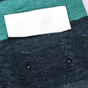 Gros plan sur le detail de la poche du short de bain pour homme avec des oeillets.