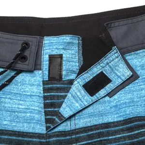 Dettaglio pantaloncini da bagno uomo, tessuto elasticizzato, coulisse, righe blu e nere.
