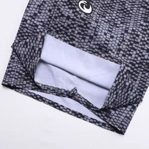 Gros plan détail de short de bain pour homme avec motif géométrique noir et gris.