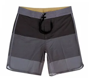 Close-up detail of mens colorblocked board shorts with elastic drawstring waist and quick dry fabric.