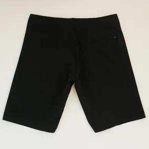 Dettaglio di pantaloncini da bagno elastici neri con tasca posteriore con cerniera.
