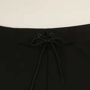 Primo piano della cintura dei pantaloncini neri con coulisse regolabile e occhielli.
