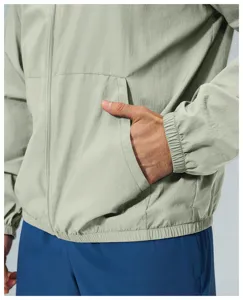 Men outdoor sports jacket pocket detail close up, lightweight breathable fabric green zipper top.