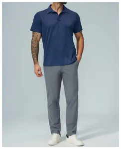 Detail shot of men's dark blue polo shirt and grey casual trousers in studio setup.