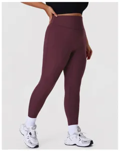 High-waisted maroon yoga leggings detail shot, featuring seamless shaping and soft workout fabric.