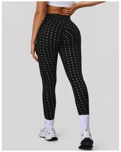Detail van de achterkant van zwarte polkadots sportleggings met hoge taille en push-up.