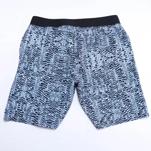 Short de plage homme imprimé géométrique bleu séchage rapide, détail tissu extensible.