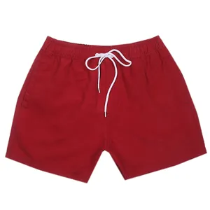Vista dettagliata di pantaloncini da mare rossi da uomo con un cordoncino bianco.