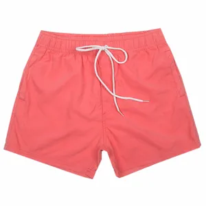 Pantaloncini da bagno rosa tinta unita da uomo con coulisse bianca per il mare.