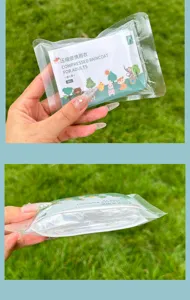 Vue détaillée de l'imperméable jetable compressé, emballage portable transparent avec carte.