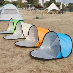 Scène extérieure montrant plusieurs tentes de plage pop-up colorées alignées sur la pelouse.