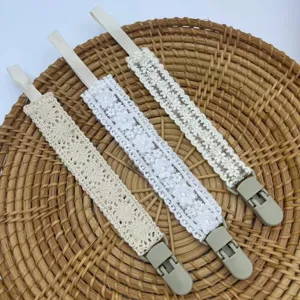 Détail d'attache tétine en dentelle, chaîne de sucette crochetée pour bébé et soulagement dentaire.