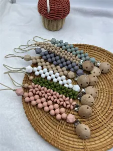 Detailed view of handmade silicone flower pacifier clips on tray, perfect for baby soothing.
