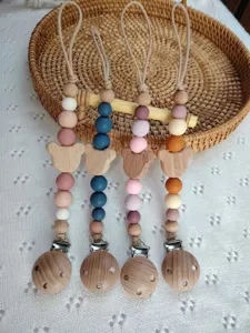 Detalle de chupetero de madera y silicona con un bonito diseño de oso y cuentas.