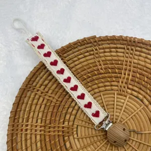 Vintage Stoff Schnullerclip mit rotem Herzstickerei und praktischem Holzclip fur Babys.