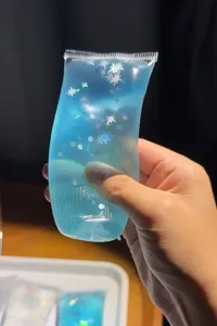 Primer plano de un juguete antiestrés de tubo de pasta de dientes con purpurina azul.
