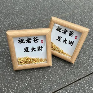 Detail van houten fotolijst met miniatuur goudstaven en gelukstekst voor vaderdagcadeau.