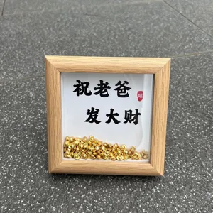 Houten fotolijst detail met miniatuur goudstaven en vaders zegentekst.