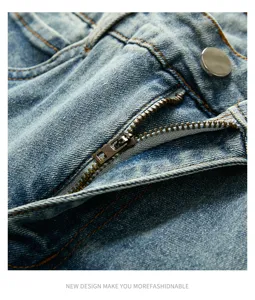 Close-up detail of men vintage washed jeans zipper and metal button, textured denim fabric.