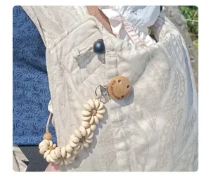 Silicone daisy pacifier clip with engraved wooden holder, cute baby teething accessory.