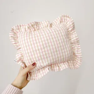 Pink gingham baby pillow with ruffles, soft ramie nap cushion for soothing and sleeping.