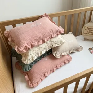 Cotton muslin baby pillow with cute ruffles, rectangular infant bed cushion and nursery decor.