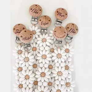 Personalized wooden pacifier clip with white silicone daisy beads for baby teething soothing.