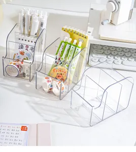 Organisateur de bureau en plastique transparent avec plusieurs compartiments inclinés pour stylos.