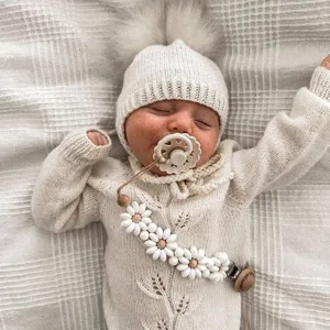 Charming knitted baby outfit with cute daisy silicone pacifier clip for daily soothing use.