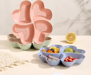 Close-up detail of clover heart-shaped compartmentalized fruit plate filled with fresh fruits.