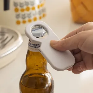 Magnetic bottle opener for kitchen fridge, minimalist white design for easy beer bottle opening.