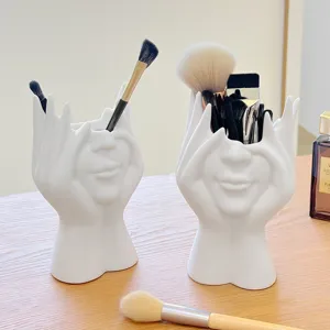 Detailansicht des kreativen Make-up-Pinselhalters mit Gesicht, eleganter weißer Stifthalter.