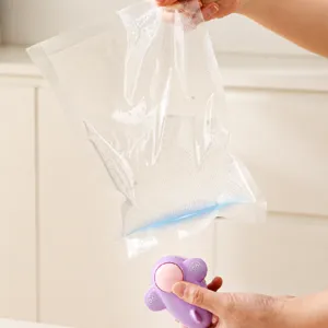 Portable mini heat sealing machine and plastic food vacuum storage bags set for snack preservation.