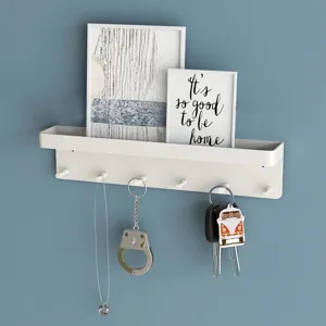 Witte wandplank met haken, ideaal voor het netjes organiseren van sleutels en kleine spullen.