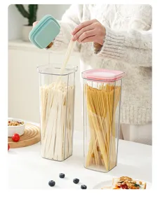 Close-up detail showing transparent plastic noodle storage canister in a clean kitchen scene.