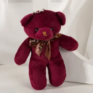 Close-up of a wine red plush teddy bear keychain charm with a brown Love ribbon bow