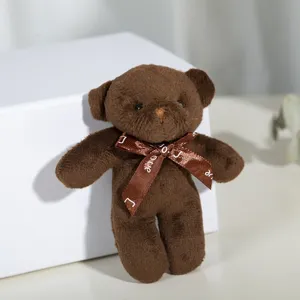 Close-up of a brown plush teddy bear keychain with a decorative LOVE ribbon bow
