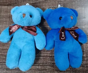 Two adorable blue plush teddy bear keychains with 'Love' printed ribbons on a wood surface