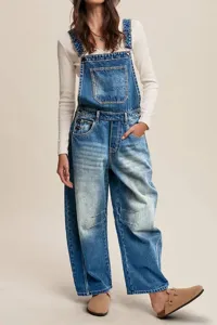 Women denim overalls detail shot showing classic straight leg cut, front pocket and casual style.